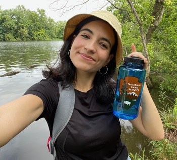 Nicole Segnini Podcast woman posing at a park with a national park service water bottle